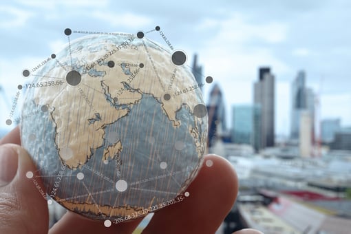 Close up of businessman hand holding a small globe.